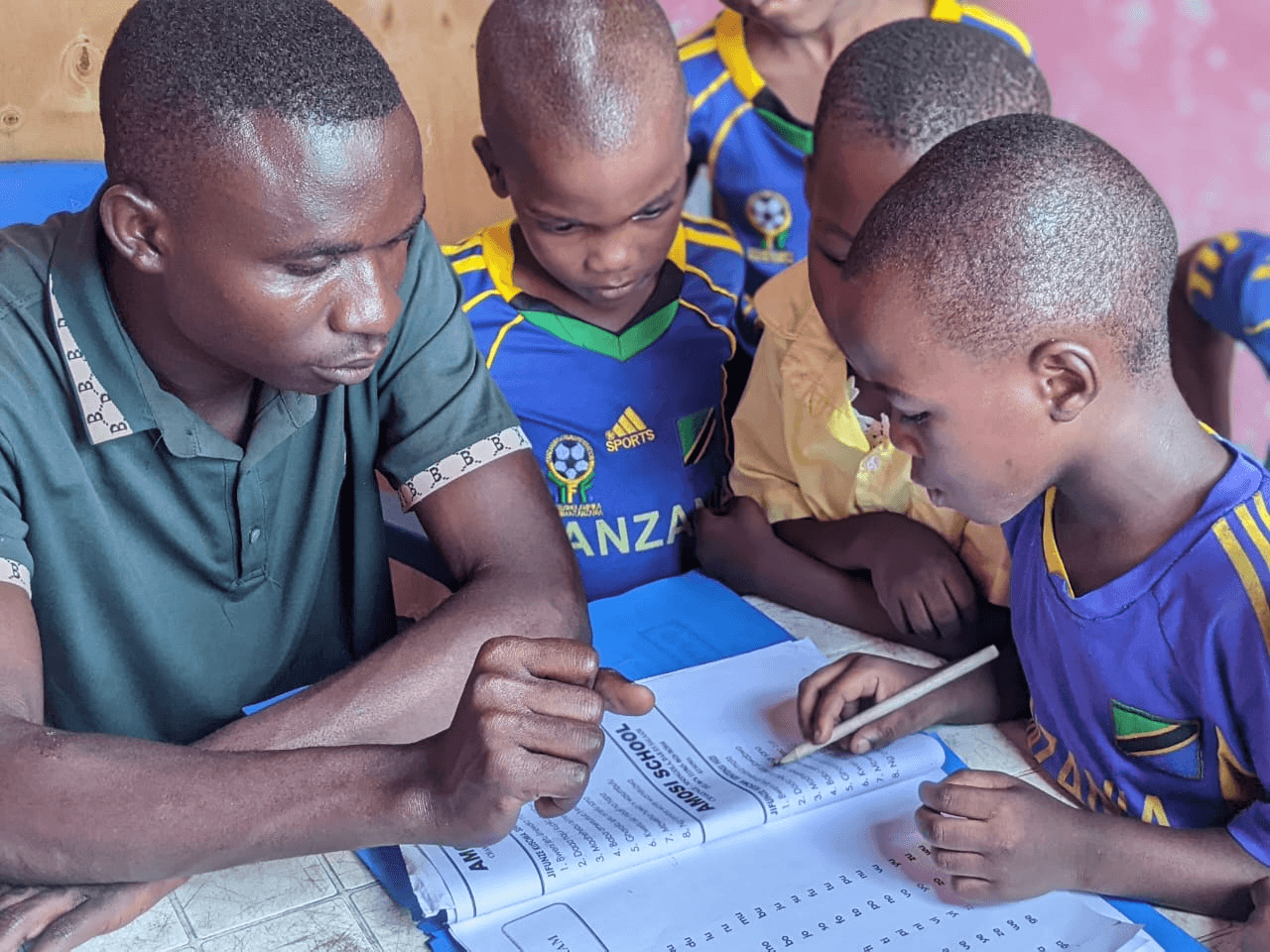 Teacher guiding Amosi Schools students during a lesson